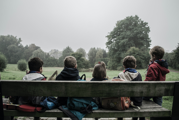 Children sitting on a bench.