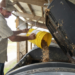 A man dumping food waste into a composter.