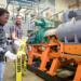 Ph.D. student Thabiso Mabote, left, and College of Engineering faculty member Eduardo Cotilla-Sanchez put caution tape around a machine testbed. Machine testbeds are useful to validate machine dynamics in a time-domain simulation such as was used in the smart meter research. (photo provided by Eduardo Cotilla-Sanchez)