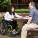 Woman with spinal cord injury seated with caregiver