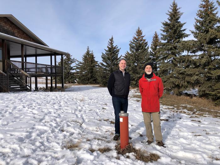 Aaron Goodarzi (left) and Henk de Haan stand at the well head on De Haan's property.