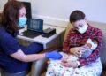 Doctor, mother and baby using the device